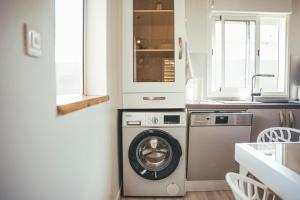 een keuken met een wasmachine en een wastafel bij Villa Swany in Petit-Bourg