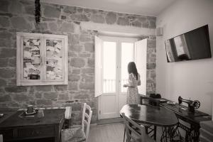 a woman standing in a room looking out a window at La Casa dei Panorami di Colobraro in Colobraro