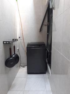 a small bathroom with a black trash can in a room at Koral Guesthouse in Malang