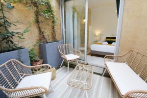 - un balcon avec 2 chaises et un lit dans une chambre dans l'établissement Appartement Sarlovèze - Stay in Sarlat, à Sarlat-la-Canéda