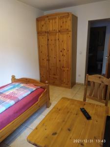 1 dormitorio con 1 cama y armario de madera en Ruhe-Nescht, en Vaihingen an der Enz
