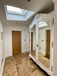 a large mirror in a room with a skylight at Tranquil, secluded, rural cottage for two in Beaumaris