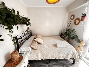 departamento encantador céntrico con balcon في ليما: غرفة نوم مع سرير والكثير من النباتات