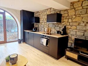 a kitchen with a stone wall and a stove at La Cachette de Simone in Spa