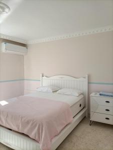 a white bedroom with a white bed and a dresser at Holistic Balance 