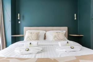 uma cama branca com toalhas e almofadas em Modern 2 bedrooms near Louvre em Paris