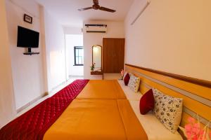 Habitación con cama grande y TV. en VKG Hotels en Pondicherry
