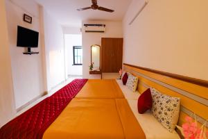 a room with a large bed and a television at VKG Hotels in Pondicherry