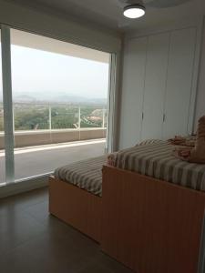 een slaapkamer met een bed en een groot raam bij Apartment in Emblematic Building in Canet de Berenguer