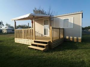 a small house with a porch and a deck at Oh! Camping - Les Roquilles Palavas les Flots in Palavas-les-Flots
