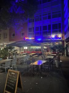 a group of tables and chairs in front of a building at Maxim Apartments Mainz in Mainz