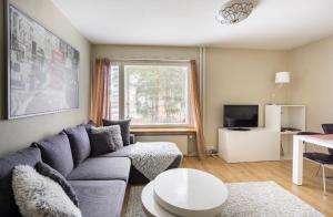 a living room with a couch and a table at FlatsinRoi Apartments in Rovaniemi