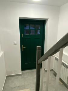 eine grüne Tür im Flur mit einer Treppe in der Unterkunft Złoty Zakątek in Złoty Stok