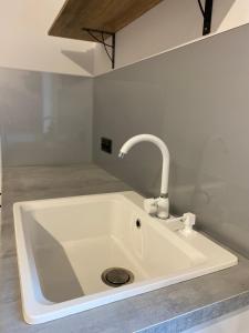 a white sink with a faucet in a room at Złoty Zakątek in Złoty Stok