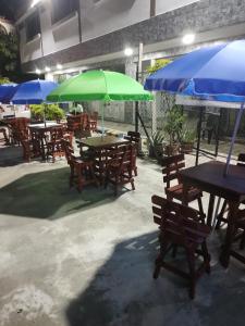 een groep tafels en stoelen met parasols bij HOTEL MANANTIAL 1 in Playa Dormida