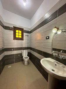 a bathroom with a toilet and a sink and a window at Seven Heaven Hotel And Diving Center in Dahab