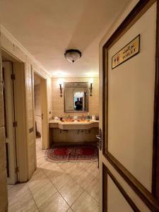 y baño con bañera, lavabo y espejo. en Sakkara Royal House, en El Cairo