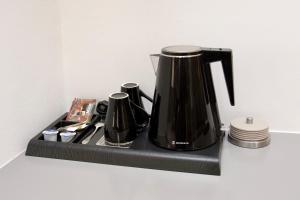 a black coffee pot sitting on a black shelf at Arxontiko Hotel in Mirina