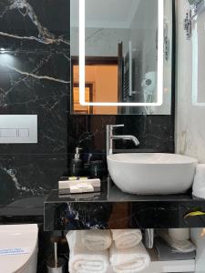 a bathroom with a sink and a mirror at Arxontiko Hotel in Mirina