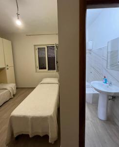 a room with two beds and a sink and a tub at Casa in Crotone