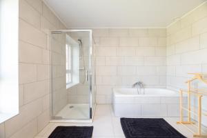 een badkamer met een douche, een bad en een wastafel bij Les Gîtes de Juliane et Eric in Gedinne