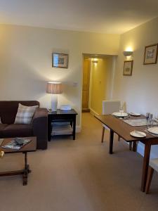 a living room with a couch and a table at Ground Floor Garden Cottage, near Stonehenge in Shrewton