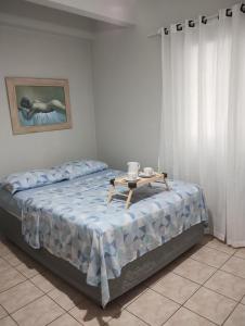 a bedroom with a bed with a table on it at Apto Rua da Praia in Florianópolis