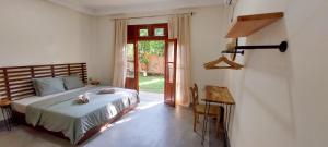 ein Schlafzimmer mit einem Bett und einer Tür zum Hof in der Unterkunft The Native Weligama in Weligama