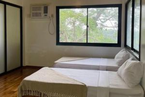 Habitación con 2 camas y ventana en Country Villa Cagayán de Oro Filipinas en Cagayán de Oro