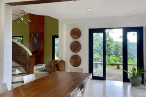 a dining room with a wooden table and glass doors at Country Villa Cagayán de Oro Filipinas in Cagayan de Oro
