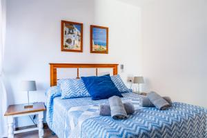 a bedroom with a bed with blue sheets and two lamps at Apartamento IRMASOL in Torre del Mar