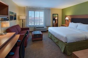 a hotel room with a bed and a couch at TownePlace Suites by Marriott Albuquerque North in Albuquerque