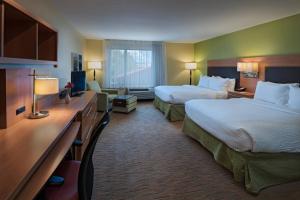 a hotel room with two beds and a desk at TownePlace Suites by Marriott Albuquerque North in Albuquerque