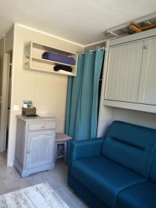 uma sala de estar com um sofá azul e uma mesa em Studio chaleureux à LANSLEVILLARD VAL CENIS 2 pers em Lanslevillard