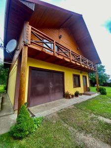 a small yellow house with a large garage at Садиба Орхідея Шешори in Sheshory