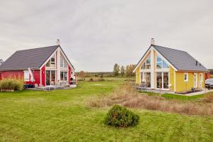 two houses in a field with a yard at Familienhaus in der Schorfheide in Wandlitz