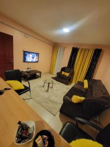 sala de estar con sofá y TV en G&G Homes Pipeline Nakuru, en Nakuru