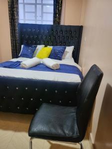 1 cama con silla de cuero negro en una habitación en G&G Homes Pipeline Nakuru, en Nakuru