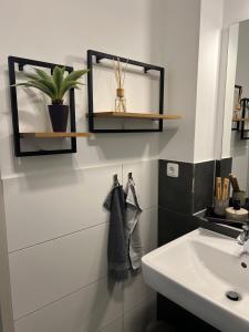 La salle de bains blanche est pourvue d'un lavabo et d'un miroir. dans l'établissement Charming Homes - Studio 10, à Wolfsburg