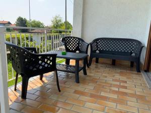 un patio con 3 sillas y una mesa en el balcón en La Casetta, en Pombia