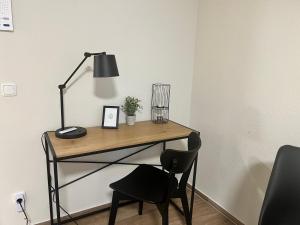 - un bureau avec une lampe et une chaise dans la chambre dans l'établissement Charming Homes - Studio 10, à Wolfsburg