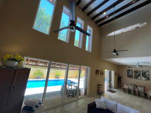 uma sala de estar com uma ventoinha de tecto e uma piscina em ARRECIFES HOUSE 100 meters from the beach em Cancún