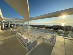 een balkon met witte stoelen en uitzicht op de oceaan bij Apartment in Emblematic Building in Canet de Berenguer