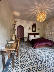 ein Schlafzimmer mit einem Bett und einem Tisch darin in der Unterkunft Boutique Guesthouse Dar Zohra in Marrakesch