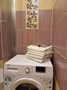 a stack of towels sitting on top of a washing machine at Iļģuciema Apartment in Rīga