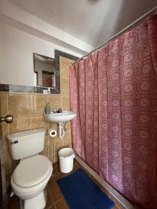 a bathroom with a toilet and a sink at Zoola Suites Antigua in Antigua Guatemala
