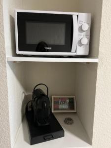 a microwave sitting on a shelf with a purse at Charming Homes - Studio 11 in Wolfsburg