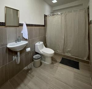 a bathroom with a toilet and a sink at Zoola Suites Antigua in Antigua Guatemala +62 photos