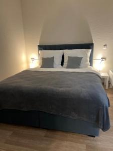 a bedroom with a large bed with two lamps at Charming Homes - Studio 11 in Wolfsburg
