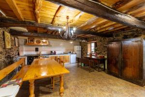 uma grande cozinha com uma mesa de madeira num quarto em Casa Ruperto em Doade